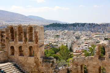Fototapeta na wymiar Ruins of ancient theater on the Acropolis with cityscape of Athenas. The Odeon of Herodes Atticus on the south slope of the Acropolis in Athens, Greece. 