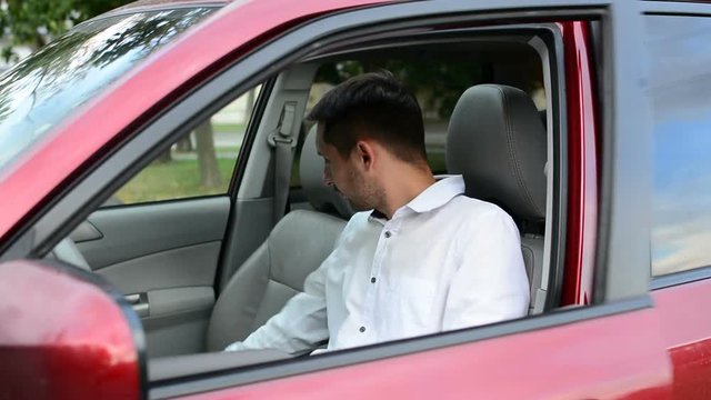 Young driver being impatient, waiting inside his car and showing signs of frustration.