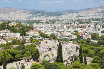 Fototapeta na wymiar Areopagus rock with tourists and Athens Cityscape from the Acropolis, Greece