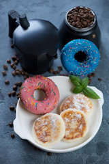 Moka coffee pot with donuts and curd pancakes or syrniki for breakfast, studio shot, selective focus