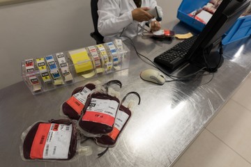 Laboratory technician scanning bar code of blood bags