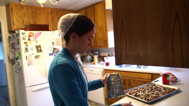 A Mennonite woman prepares food in her country home.