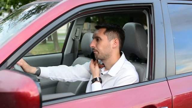 Young driver being impatient, waiting inside his car and showing signs of frustration.