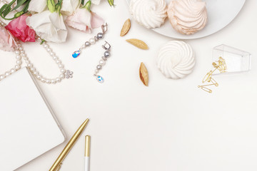 Beauty blog background. Gold style feminine accessories. Golden tinsel, scissors, pen, rings, necklace, bracelet , flowers and sweety on light background. Flat lay, top view