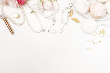 Beauty blog background. Gold style feminine accessories. Golden tinsel, scissors, pen, rings, necklace, bracelet , flowers and sweety on light background. Flat lay, top view
