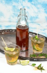 Fresh homemade lemonade with lime and mint / Drink in glasses on metal tray, brown sugar and peppermint leaves, sky background