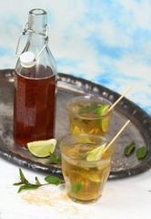 Fresh homemade lemonade with lime and mint / Drink in glasses on metal tray, brown sugar and peppermint leaves, sky background