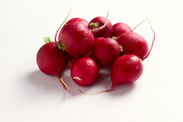Group of fresh red radishes on white surface