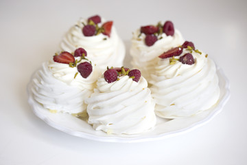 Pavlova cakes with cream and fresh summer berries