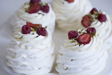 Pavlova cakes with cream and fresh summer berries