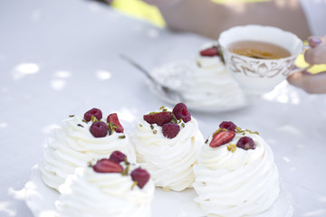 Pavlova cakes with cream and fresh summer berries