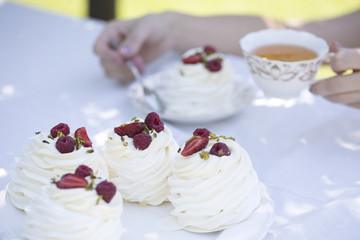 Pavlova cakes with cream and fresh summer berries