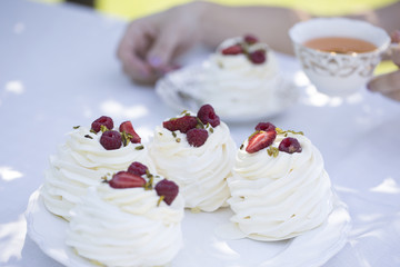 Pavlova cakes with cream and fresh summer berries
