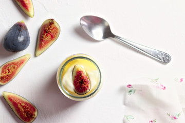 Yogurt with honey and fresh cut figs on white surface, flat lay