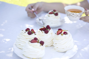 Pavlova cakes with cream and fresh summer berries