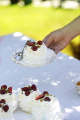 Pavlova cakes with cream and fresh summer berries