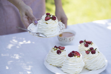 Pavlova cakes with cream and fresh summer berries