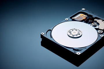 disassembled hard drive and tools are on the operating table