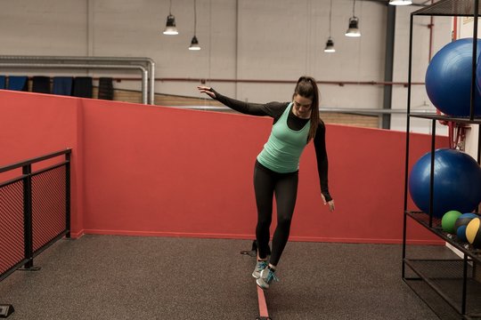 Woman doing exercise with rubber band in fitness gym