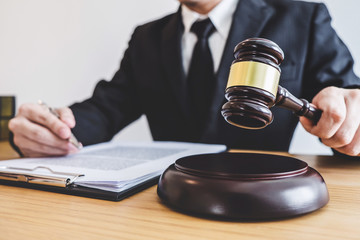 Judge gavel with Justice lawyers, counselor in suit or lawyer working on a documents at law firm in...