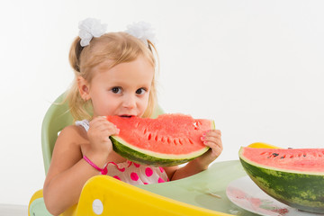 A child, a little girl, appetizingly eats a juicy watermelon.