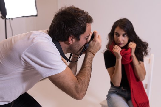 Male photographer clicking photos of model