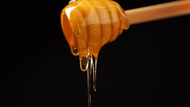 Footage organic honey dripping from wooden honey spoon background