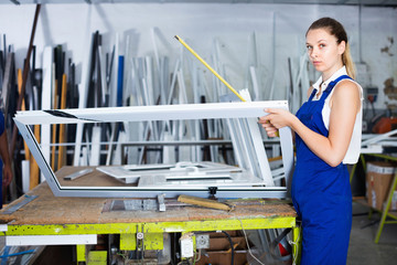 woman using measuring tape in her work in production of pvc windows