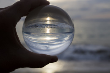 Sunset at beach through glass ball
