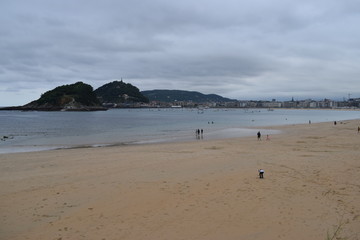 Playa y zona costera de una ciudad en un día nublado.