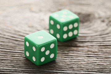 Green dice on grey wooden table