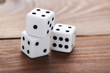 White dice on brown wooden table
