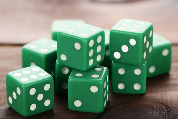 Green dice on brown wooden table
