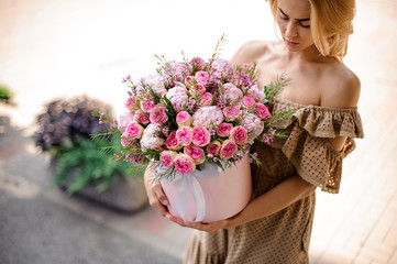 Young beautiful girl holding in her hands a bouquet of tender pink flowers - Powered by Adobe