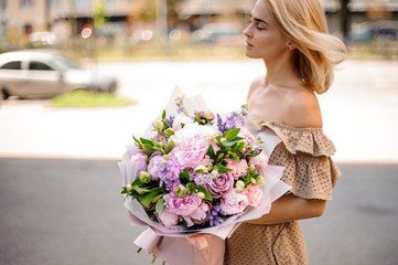 Young beautiful girl holding a bouquet of tender flowers