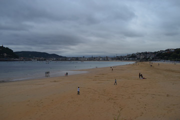 Fototapeta na wymiar Playa y zona costera de una ciudad en un día nublado.