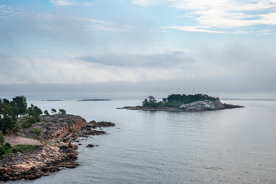 Beautiful nordic archipelago summer view  of land and island against sea and hazy horizon.