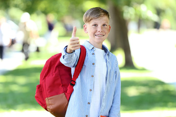 Young boy with red backpack in the park