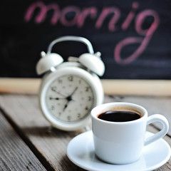 Cup of coffee with blackboard and alarm clock on vintage wooden background TONING