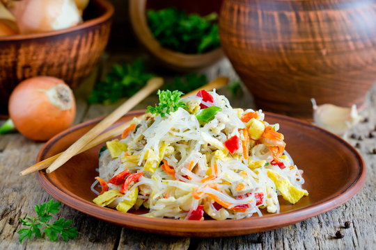 Chicken pad thai rice noodles with fried egg, onion, carrot, pepper