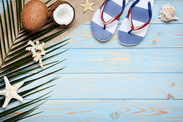 Coconuts with seashells and flip flops on wooden table