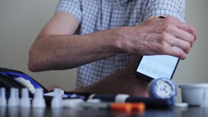 A man hands brings to the hand the smartphone for measuring glucose in the blood
