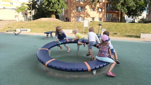 Many children have fun enjoy play and spin on outdoors playground in a city, one boy fail falling