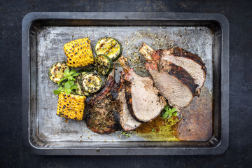 Traditionel barbecue veal back racks carree roast with corn and zucchini as top view on an old griddle © HLPhoto