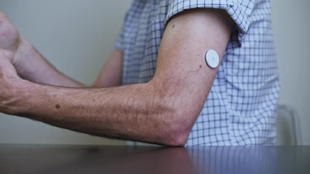 A man hands brings to the hand the smartphone for measuring glucose in the blood