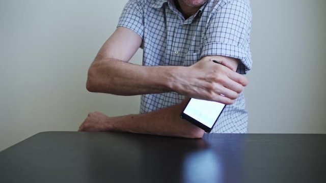 A man hands brings to the hand the smartphone for measuring glucose in the blood