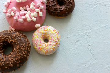 Photos of different donuts. Assorted colorful donuts in glaze close-up, free space for writing textsn