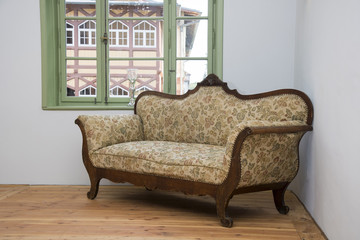 altes barocke Sofa in einem restaurierten leeren Raum mit Fenster