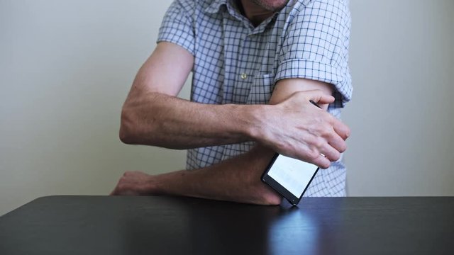 A man hands brings to the hand the smartphone for measuring glucose in the blood