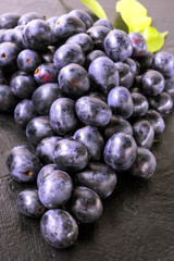 Fresh ripe Bunches of black Grapes berries on kitchen table